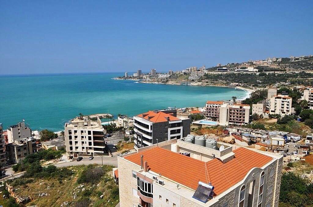 Turquoise water curving around Jounieh bay below the residence